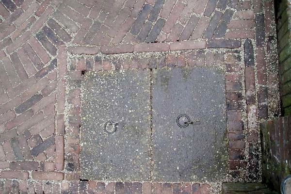 Bestrating van oude walen met nostalgisch putdeksel in Uitgeest