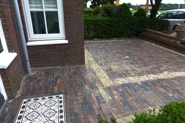 Sierbestrating van nieuw gebakken walen met stoepje van Portugese tegels in Haarlem