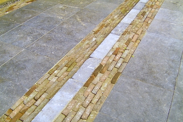 Bestrating van natuurstenen tegels met rand van gebakken walen in Amstelveen