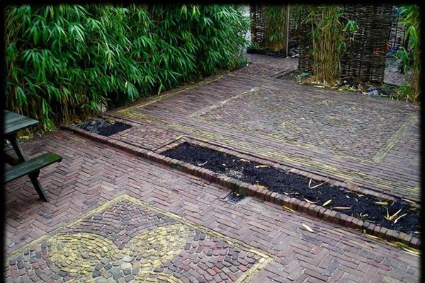 Sierbestrating van oude walen met bloem van boerengeeltjes in Heiloo