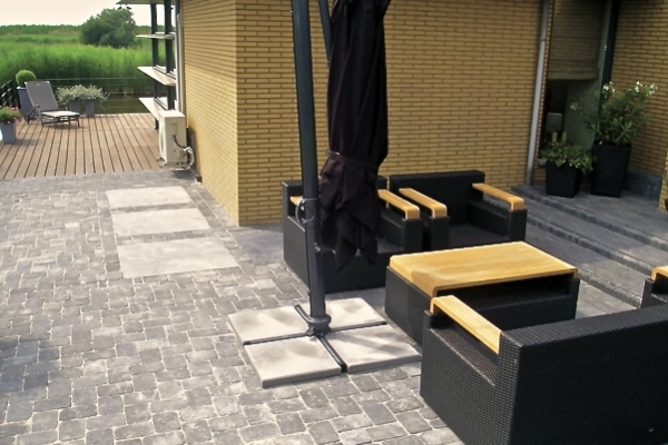 Bestrating van betonnen getrommelde stenen met 1mx1m-natuurstenen tegels in Purmerend